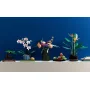 Rosa-weiße LEGO-Orchidee in grau gestreiftem Topf auf weißem Regal neben anderen botanischen Pflanzen