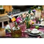 Bouquet de fleurs LEGO colorées dans un vase avec tiges vertes, posé sur une table dressée avec vaisselle et verres