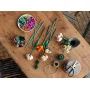 Vue d'ensemble du set LEGO assemblé montrant plusieurs fleurs colorées avec tiges vertes disposées sur une table en bois