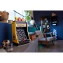 Borne d'arcade PAC-MAN LEGO jaune avec écran de jeu et figurines colorées, posée sur un meuble blanc dans un salon moderne