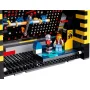 Gros plan de la borne d'arcade LEGO PAC-MAN avec écran de jeu, manettes bleues, figurine joueur et mécanisme interne visible