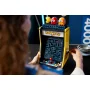 Borne d'arcade LEGO PAC-MAN jaune avec écran de jeu, figurines Pac-Man et fantômes colorés au sommet, tenue par une personne