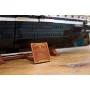 Navire LEGO Endurance avec coque noire et détails blancs, accompagné de sa plaque dorée d'informations sur socle en bois
