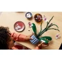 Mains assemblant une orchidée LEGO avec fleurs roses et feuilles vertes, sur table avec bols décoratifs et pétales éparpillés Mains assemblant une orchidée LEGO avec fleurs roses et feuilles vertes, sur table avec bols décoratifs et pétales éparpillés