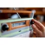 Main tournant le bouton de volume noir de la radio rétro LEGO orange et verte avec antenne télescopique déployée Main tournant le bouton de volume noir de la radio rétro LEGO orange et verte avec antenne télescopique déployée
