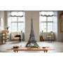 Maquette LEGO de la tour Eiffel noire assemblée, posée sur une table en bois dans un salon moderne avec fenêtres et mobilier
