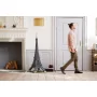 Set LEGO tour Eiffel assemblée en noir dans un salon moderne avec cheminée, homme marchant en arrière-plan