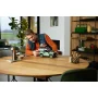 Homme assemblant le modèle LEGO Land Rover Defender 90 vert sur une table en bois dans un salon moderne Homme assemblant le modèle LEGO Land Rover Defender 90 vert sur une table en bois dans un salon moderne
