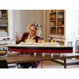 Femme construisant le modèle LEGO Titanic sur une table, navire avec 4 cheminées jaunes et coque noire visible Femme construisant le modèle LEGO Titanic sur une table, navire avec 4 cheminées jaunes et coque noire visible