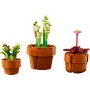 Trois pots de fleurs LEGO avec plantes : un cactus violet, des tiges carnivores vertes et une fleur rose sur tige rouge Trois pots de fleurs LEGO avec plantes : un cactus violet, des tiges carnivores vertes et une fleur rose sur tige rouge