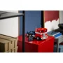 Optimus Prime LEGO en mode camion rouge et bleu posé sur un cube rouge, dans un environnement moderne avec étagères Optimus Prime LEGO en mode camion rouge et bleu posé sur un cube rouge, dans un environnement moderne avec étagères