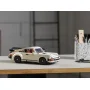 Modèle LEGO Porsche 911 blanc cassé avec aileron noir posé sur un bureau en bois à côté d'un pot à crayons Modèle LEGO Porsche 911 blanc cassé avec aileron noir posé sur un bureau en bois à côté d'un pot à crayons