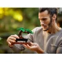 Man gently holding the LEGO bonsai with green foliage and brown trunk on wooden base in his hands Man gently holding the LEGO bonsai with green foliage and brown trunk on wooden base in his hands