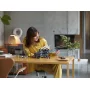 Woman in yellow dress building LEGO Atreides Royal Ornithopter model in modern living room with fireplace