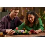 Two adults building colorful LEGO succulent plants together on a wooden table in a cozy living room setting