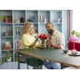 Couple building red LEGO roses in a vase on a table in a modern living room with shelving unit