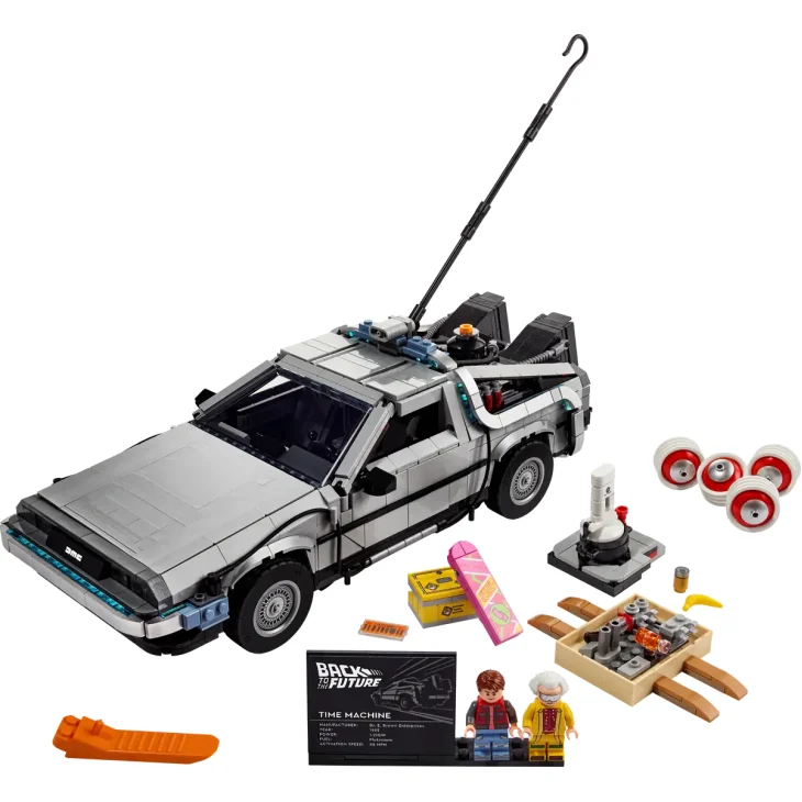 DeLorean LEGO plateado con puertas de gaviota abiertas y antena, mostrado con dos minifiguras y accesorios coloridos