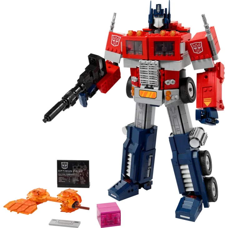 Figura robot LEGO Optimus Prime en rojo, azul y gris, sosteniendo un cañón, con accesorios y placa informativa
