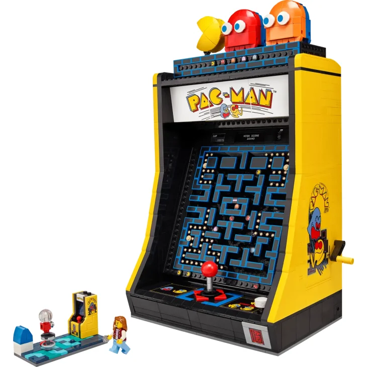 Cabinato arcade LEGO PAC-MAN giallo con schermo di gioco, figure colorate sopra e minifigure LEGO accanto