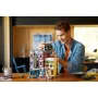 Uomo che costruisce il set LEGO Club Jazz con edificio modulare colorato e minifigure su un tavolo Uomo che costruisce il set LEGO Club Jazz con edificio modulare colorato e minifigure su un tavolo