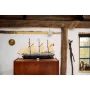 Nave LEGO Endurance con scafo nero e vele beige su mobile in legno in interno rustico con travi a vista